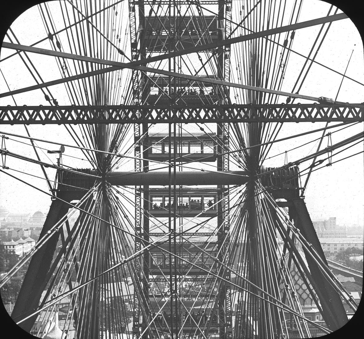 View through the support wires and passenger cars of the original Ferris Wheel, September 1893